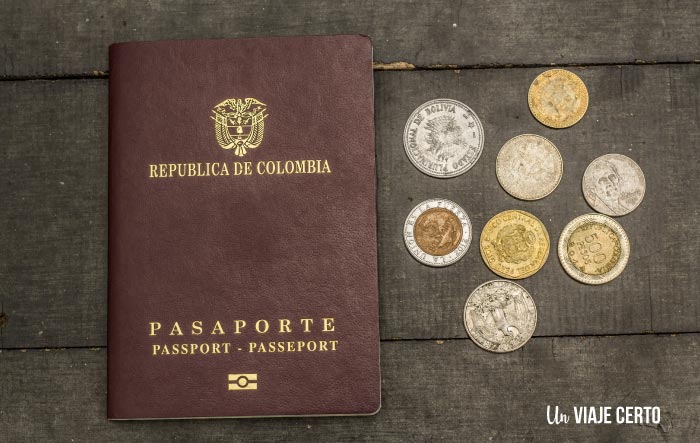Pasaporte colombiano con monedas de sudamérica